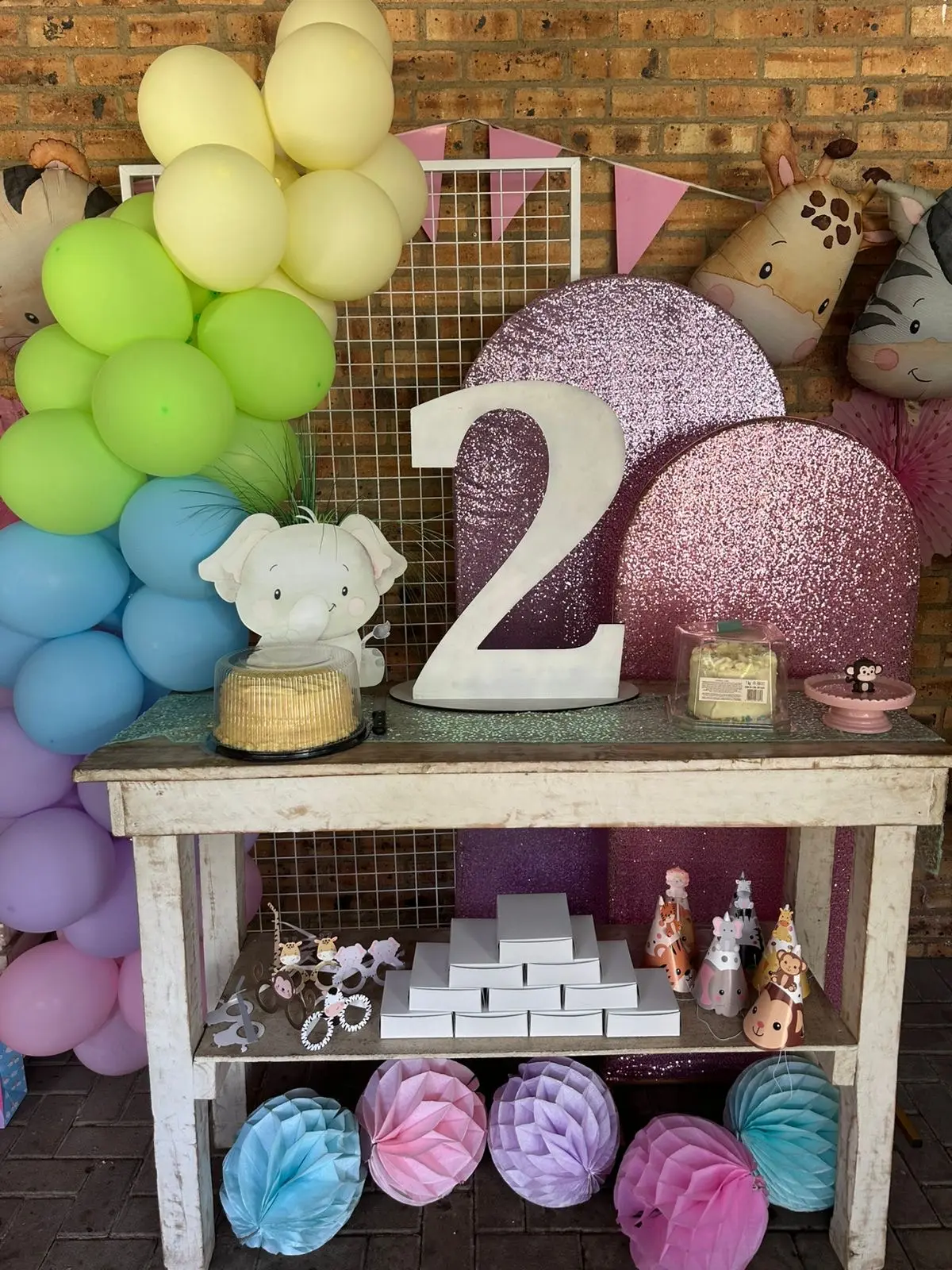 A pastel balloon wall with a big number two